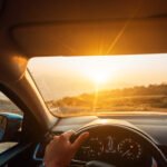 The road to success - a driver traveling on a road to the sun